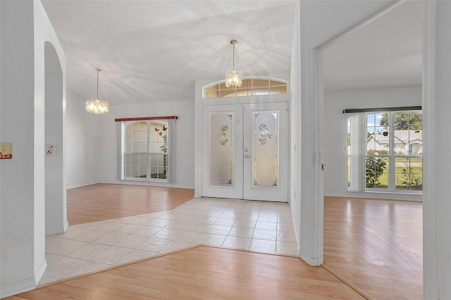 710 Independence Dr, Orange City, FL 32763 - foyer with light tile patterned flooring, arched walkways, and a chandelier