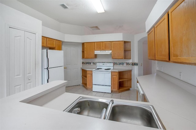 710 Independence Dr, Orange City, FL 32763 - kitchen with white appliances, open shelves, under cabinet range hood, light countertops, and brown cabinets