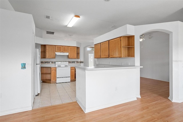 710 Independence Dr, Orange City, FL 32763 - kitchen featuring white appliances, open shelves, under cabinet range hood, brown cabinets, and light wood-style flooring