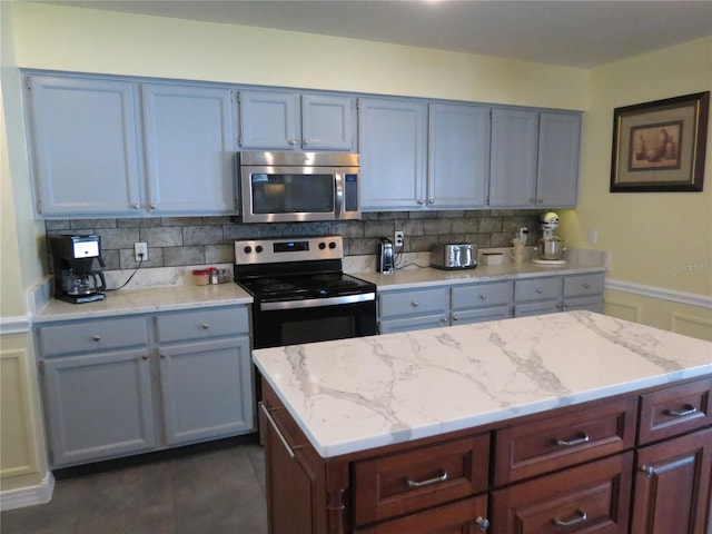 1420 Center St, Ocoee, FL 34761 - kitchen with appliances with stainless steel finishes, decorative backsplash, and light stone counters