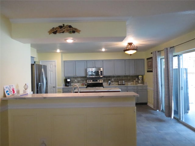 1420 Center St, Ocoee, FL 34761 - kitchen featuring stainless steel appliances, light countertops, backsplash, and a peninsula