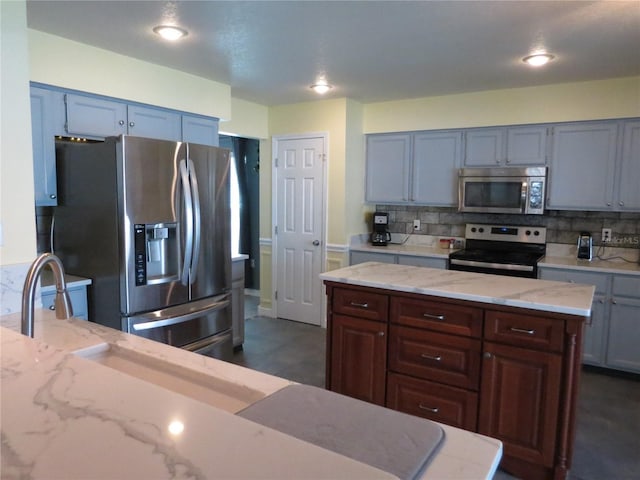1420 Center St, Ocoee, FL 34761 - kitchen with stainless steel appliances, tasteful backsplash, light stone counters, and a center island