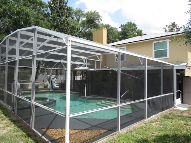 1420 Center St, Ocoee, FL 34761 - rear view of house with a lanai, stucco siding, a pool with connected hot tub, a chimney, and a patio area