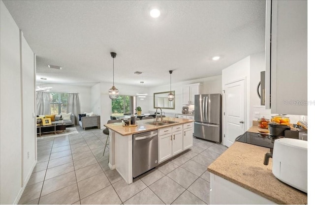 133 Hickory Course Cir, Ocala, FL 34472 - kitchen with appliances with stainless steel finishes, open floor plan, white cabinets, a kitchen island with sink, and light tile patterned floors