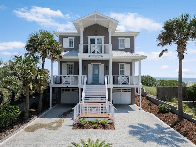 3309 Hill St, New Smyrna Beach, FL 32169 - coastal inspired home with covered porch, decorative driveway, stairway, and an attached garage