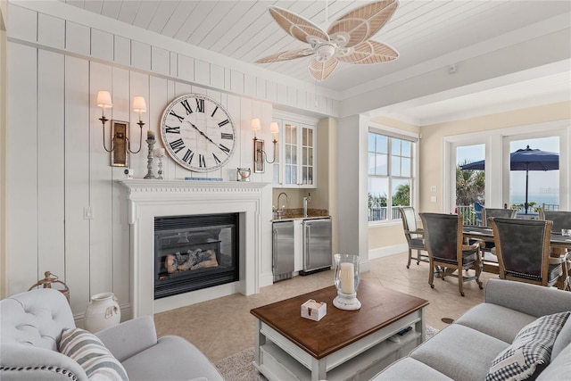 3309 Hill St, New Smyrna Beach, FL 32169 - living area with ceiling fan, bar area, light tile patterned floors, and a glass covered fireplace