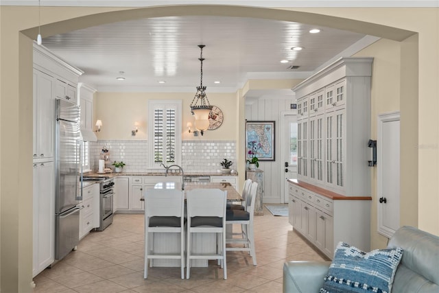 3309 Hill St, New Smyrna Beach, FL 32169 - kitchen with high end appliances, arched walkways, light stone counters, tasteful backsplash, and light tile patterned floors