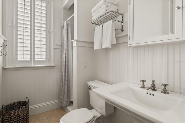 3309 Hill St, New Smyrna Beach, FL 32169 - bathroom with a shower with shower curtain, tile patterned flooring, and wainscoting