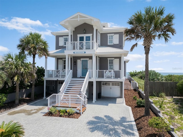 3309 Hill St, New Smyrna Beach, FL 32169 - raised beach house with covered porch, decorative driveway, stairway, a garage, and a balcony