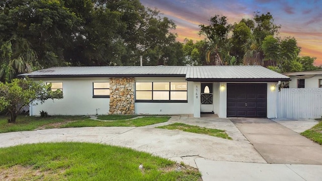 1148 Northcrest Dr, Apopka, FL 32703 - view of front of home with an attached garage, a metal roof, concrete driveway, and stucco siding