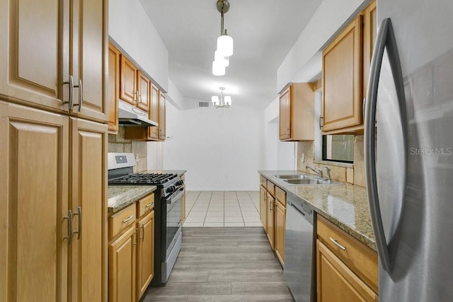 1148 Northcrest Dr, Apopka, FL 32703 - kitchen featuring appliances with stainless steel finishes, under cabinet range hood, backsplash, a chandelier, and light stone counters