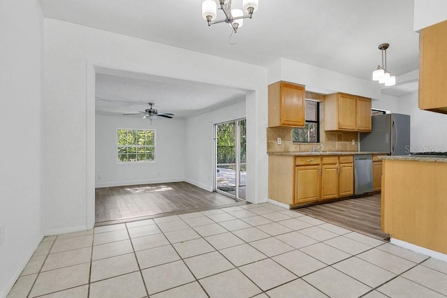 1148 Northcrest Dr, Apopka, FL 32703 - kitchen with refrigerator, stainless steel dishwasher, a chandelier, a ceiling fan, and tasteful backsplash