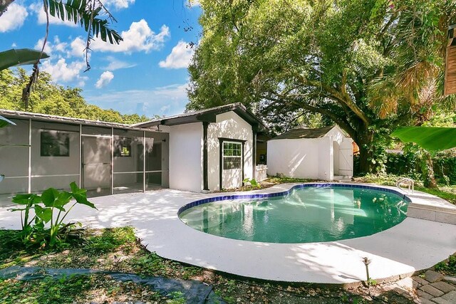 1148 Northcrest Dr, Apopka, FL 32703 - swimming pool with a sunroom, a storage shed, and a patio area