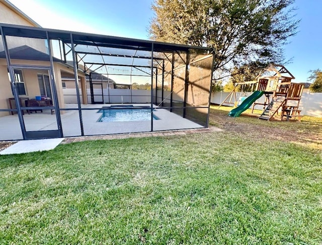 5917 Coquyt Dr, Mount Dora, FL 32757 - view of grassy yard featuring a patio, a playground, and glass enclosure
