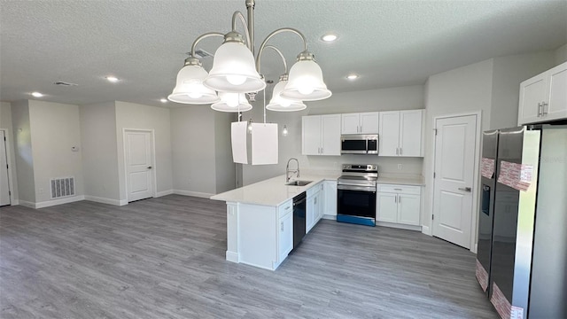 2500 SW 156th Ln Rd, Ocala, FL 34473 - kitchen with stainless steel appliances, a textured ceiling, a peninsula, white cabinetry, and open floor plan
