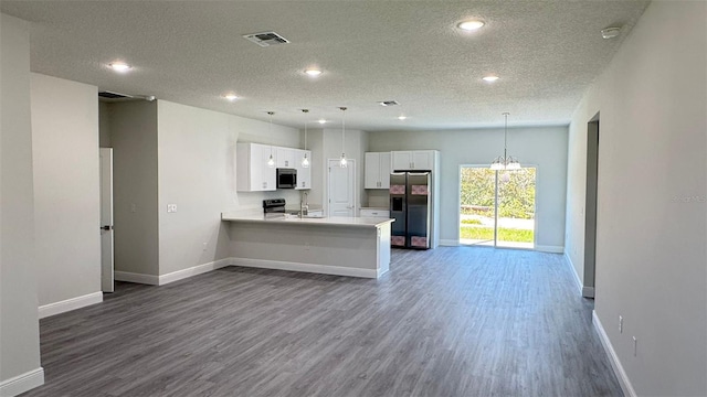 2500 SW 156th Ln Rd, Ocala, FL 34473 - kitchen with stainless steel appliances, a textured ceiling, white cabinets, open floor plan, and light countertops