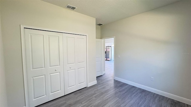 2500 SW 156th Ln Rd, Ocala, FL 34473 - unfurnished bedroom with dark wood-style floors, a closet, and a textured ceiling