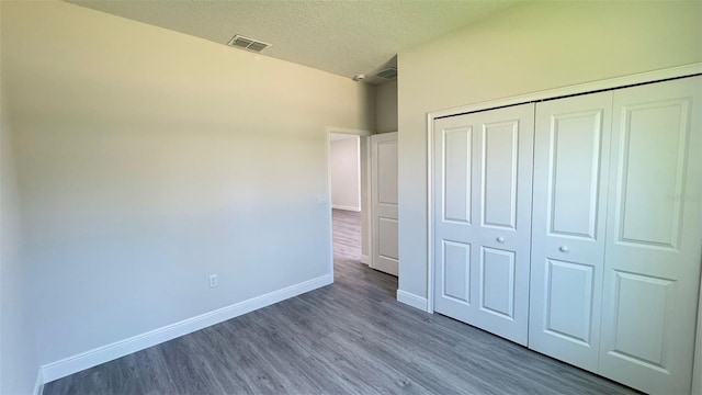 2500 SW 156th Ln Rd, Ocala, FL 34473 - unfurnished bedroom featuring wood finished floors, a textured ceiling, and a closet