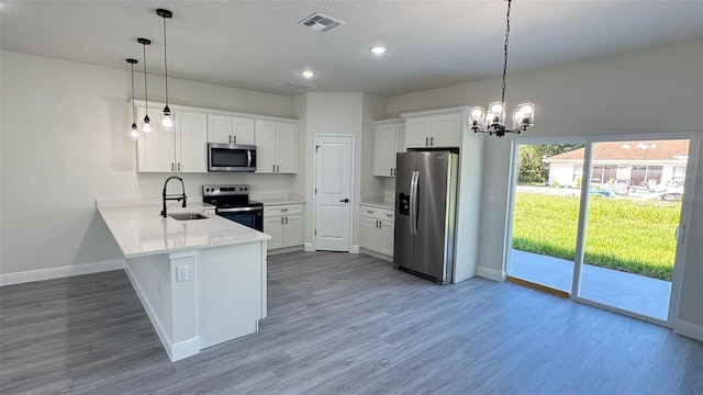 16252 SW 27th Terrace Rd, Ocala, FL 34473 - kitchen with stainless steel appliances, wood finished floors, a peninsula, light countertops, and white cabinetry