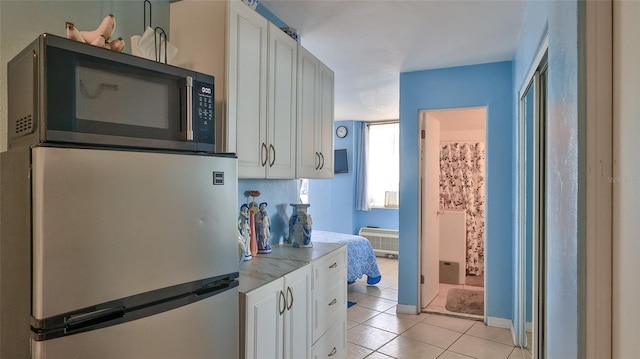 1233 N Atlantic Ave Unit 1020, Daytona Beach, FL 32118 - kitchen with appliances with stainless steel finishes, light tile patterned floors, white cabinets, and light countertops