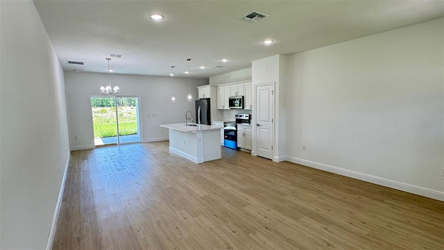 742 W Glenhaven Dr, Citrus Springs, FL 34434 - kitchen with appliances with stainless steel finishes, a chandelier, open floor plan, an island with sink, and white cabinets