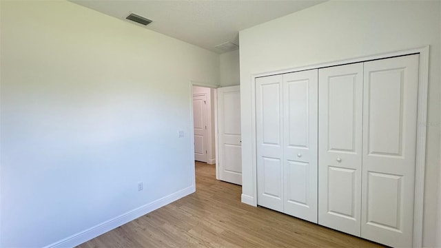 742 W Glenhaven Dr, Citrus Springs, FL 34434 - unfurnished bedroom featuring light wood-style floors and a closet