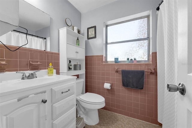 565 S Floyd Cir, Deltona, FL 32725 - bathroom featuring tile walls, tile patterned flooring, vanity, and wainscoting