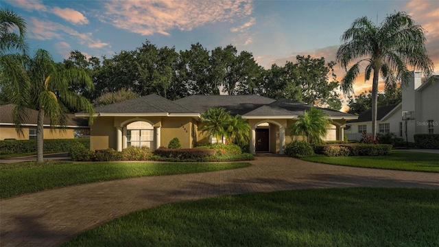1455 Royal Forest Loop, Lakeland, FL 33811 - single story home with curved driveway, a yard, and stucco siding