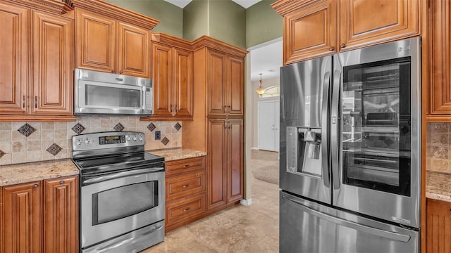 1455 Royal Forest Loop, Lakeland, FL 33811 - kitchen featuring stainless steel appliances, brown cabinetry, and light stone counters