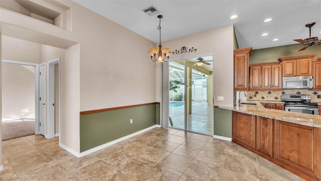 1455 Royal Forest Loop, Lakeland, FL 33811 - kitchen featuring appliances with stainless steel finishes, a ceiling fan, light stone counters, brown cabinets, and decorative backsplash