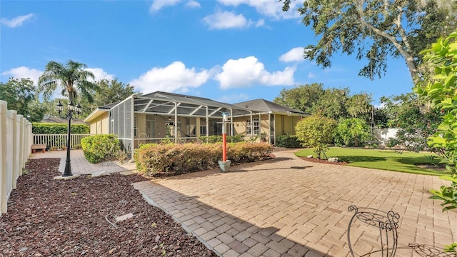 1455 Royal Forest Loop, Lakeland, FL 33811 - back of house featuring a fenced backyard, glass enclosure, and a patio