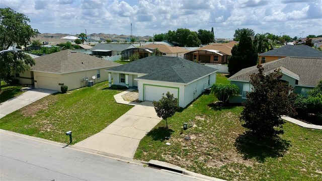 130 Winsor Ave, Davenport, FL 33837 - view of front of house featuring concrete driveway, a residential view, an attached garage, and a front lawn