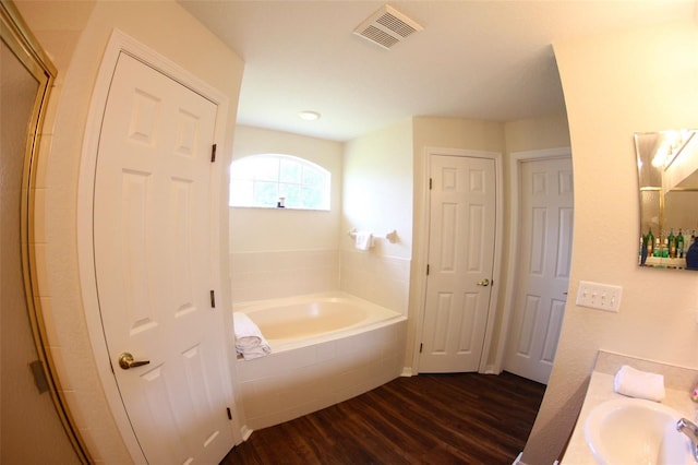 130 Winsor Ave, Davenport, FL 33837 - full bath with wood finished floors, a garden tub, vanity, and a shower with door