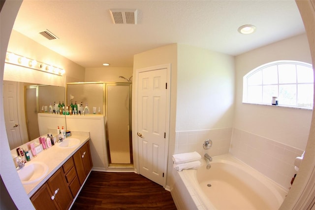 130 Winsor Ave, Davenport, FL 33837 - full bathroom with wood finished floors, a bath, a shower stall, and double vanity