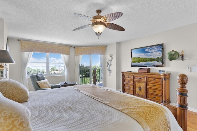 4 Oceans W Blvd Unit 502D, Daytona Beach Shores, FL 32118 - bedroom featuring a textured ceiling, multiple windows, access to outside, wood finished floors, and a ceiling fan