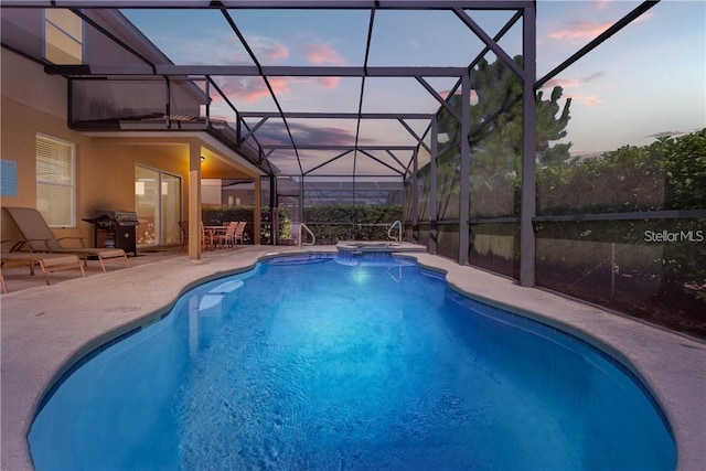 5172 Oakbourne Ave, Davenport, FL 33837 - pool at dusk with a patio, a pool with connected hot tub, and glass enclosure