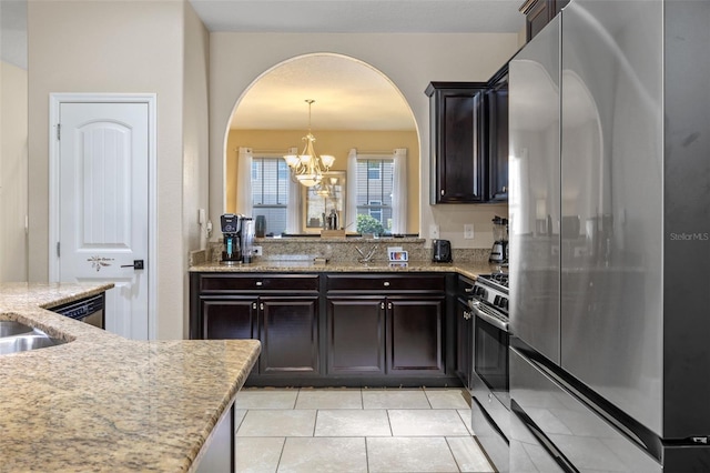 5172 Oakbourne Ave, Davenport, FL 33837 - kitchen with stainless steel appliances, arched walkways, a chandelier, light tile patterned floors, and light stone counters