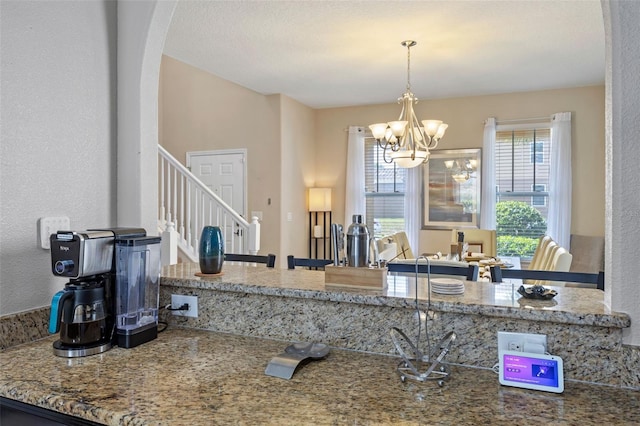 5172 Oakbourne Ave, Davenport, FL 33837 - kitchen featuring a chandelier, arched walkways, and hanging light fixtures