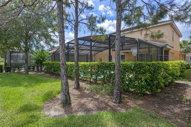 5172 Oakbourne Ave, Davenport, FL 33837 - rear view of house featuring stucco siding, a yard, and glass enclosure