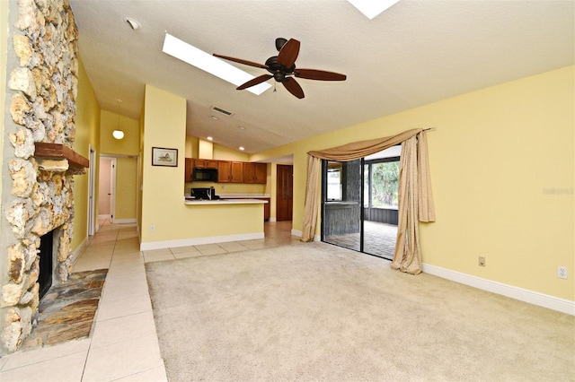 173 Tollgate Br, Longwood, FL 32750 - unfurnished living room featuring lofted ceiling, a skylight, light tile patterned floors, ceiling fan, and a fireplace