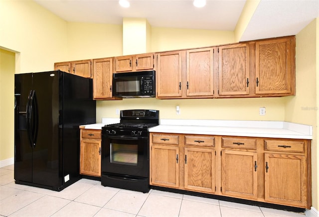 173 Tollgate Br, Longwood, FL 32750 - kitchen with black appliances, light countertops, vaulted ceiling, brown cabinetry, and light tile patterned floors