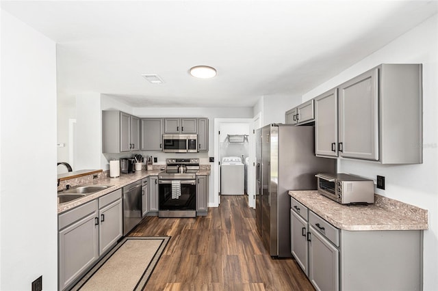 5430 NW 55th Pl, Ocala, FL 34482 - kitchen featuring stainless steel appliances, gray cabinetry, washer / dryer, and dark wood-style flooring