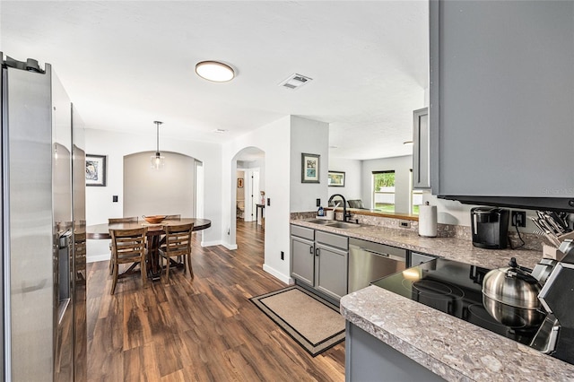 5430 NW 55th Pl, Ocala, FL 34482 - kitchen with appliances with stainless steel finishes, arched walkways, dark wood-type flooring, gray cabinets, and decorative light fixtures