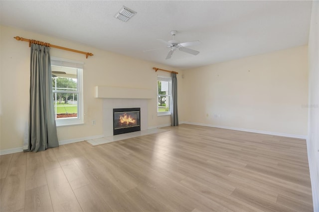 16243 Wilkinson Dr, Clermont, FL 34714 - unfurnished living room with light wood-style floors, a ceiling fan, and a tile fireplace