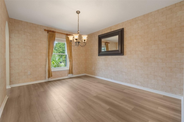 16243 Wilkinson Dr, Clermont, FL 34714 - unfurnished room featuring a chandelier, wood finished floors, and brick wall