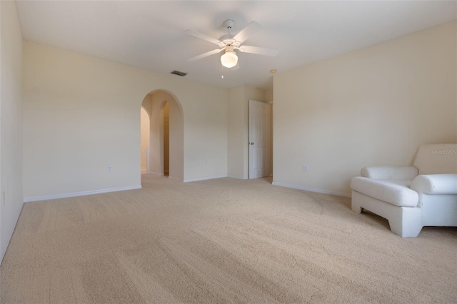 16243 Wilkinson Dr, Clermont, FL 34714 - living area with arched walkways, light colored carpet, and a ceiling fan
