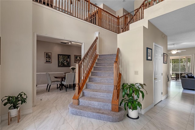1225 Hollow Pine Dr, Oviedo, FL 32765 - stairway with a ceiling fan, a towering ceiling, and marble look tiles