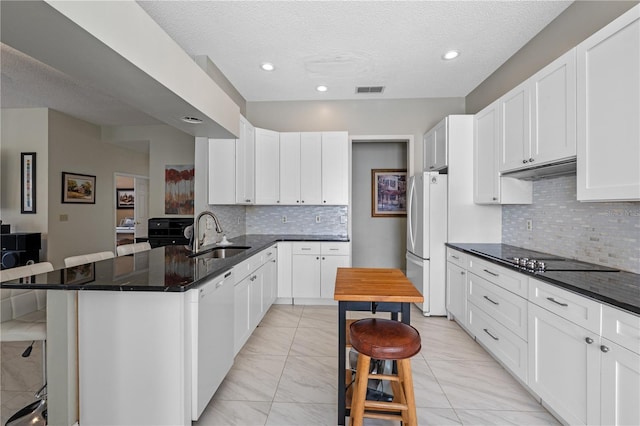 1225 Hollow Pine Dr, Oviedo, FL 32765 - kitchen featuring white appliances, light marble finish flooring, a kitchen breakfast bar, a peninsula, and tasteful backsplash