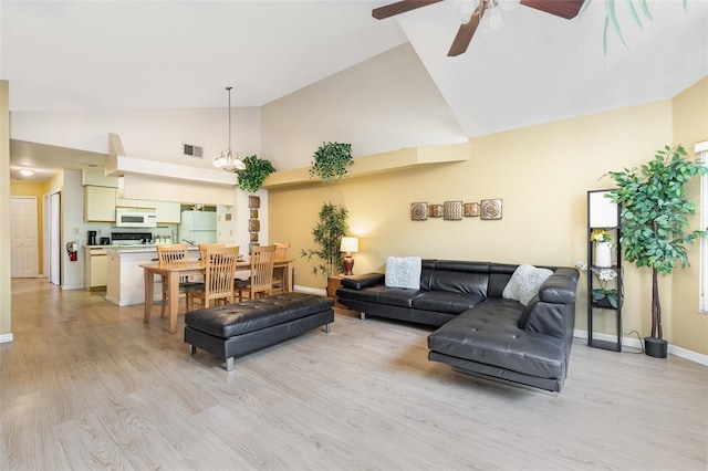 living room featuring light wood-style flooring, high vaulted ceiling, and a ceiling fan