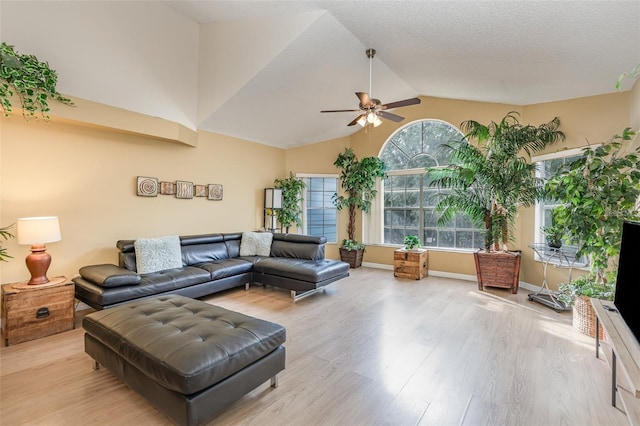 living room with ceiling fan, light wood-type flooring, and high vaulted ceiling